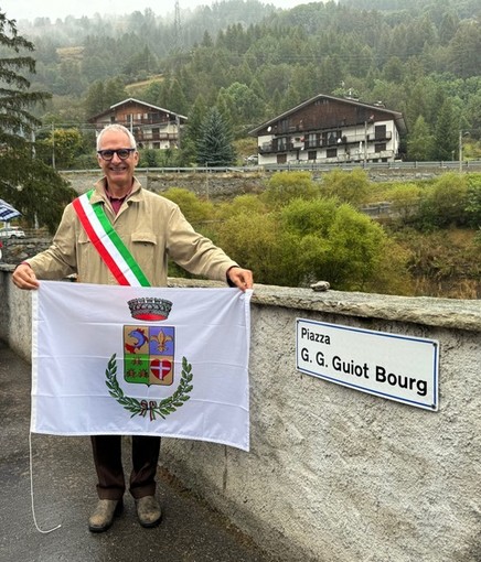 Il sindaco Massimo Marchisio di fianco al cartello della nuova piazza Guiot Bourg