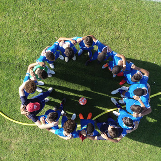 ragazzi abbracciati in mezzo al campo di calcio