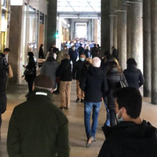 persone sotto i portici in via Roma