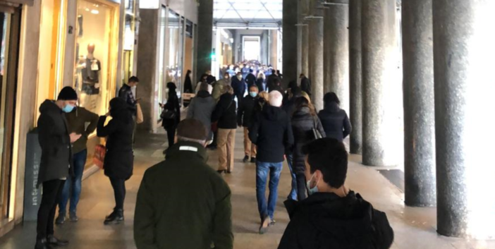 persone sotto i portici in via Roma